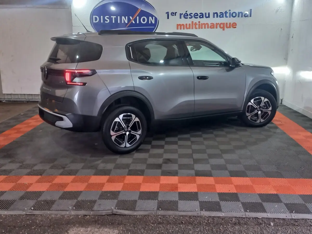 Vue de profil droit d'un Citroën C3 gris foncé hybride 2025, avec jantes modernes et feux arrière allumés.