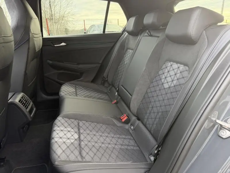 Vue intérieure arrière côté droit de la Volkswagen Golf 1.5 eTSI EVO2 R-Line 2025, sièges gris à motifs géométriques et finitions cuir.