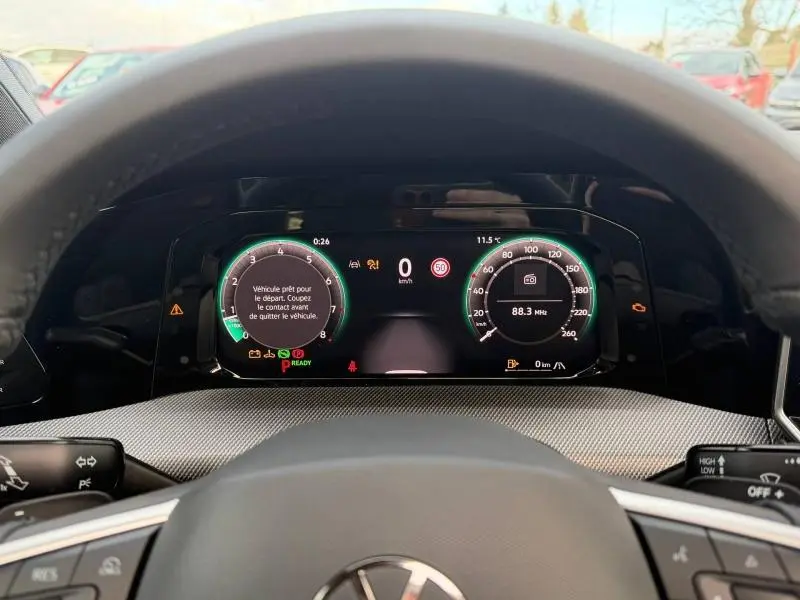 Vue du tableau de bord numérique de la Volkswagen Golf gris 2025, affichant les compteurs et alertes au volant.