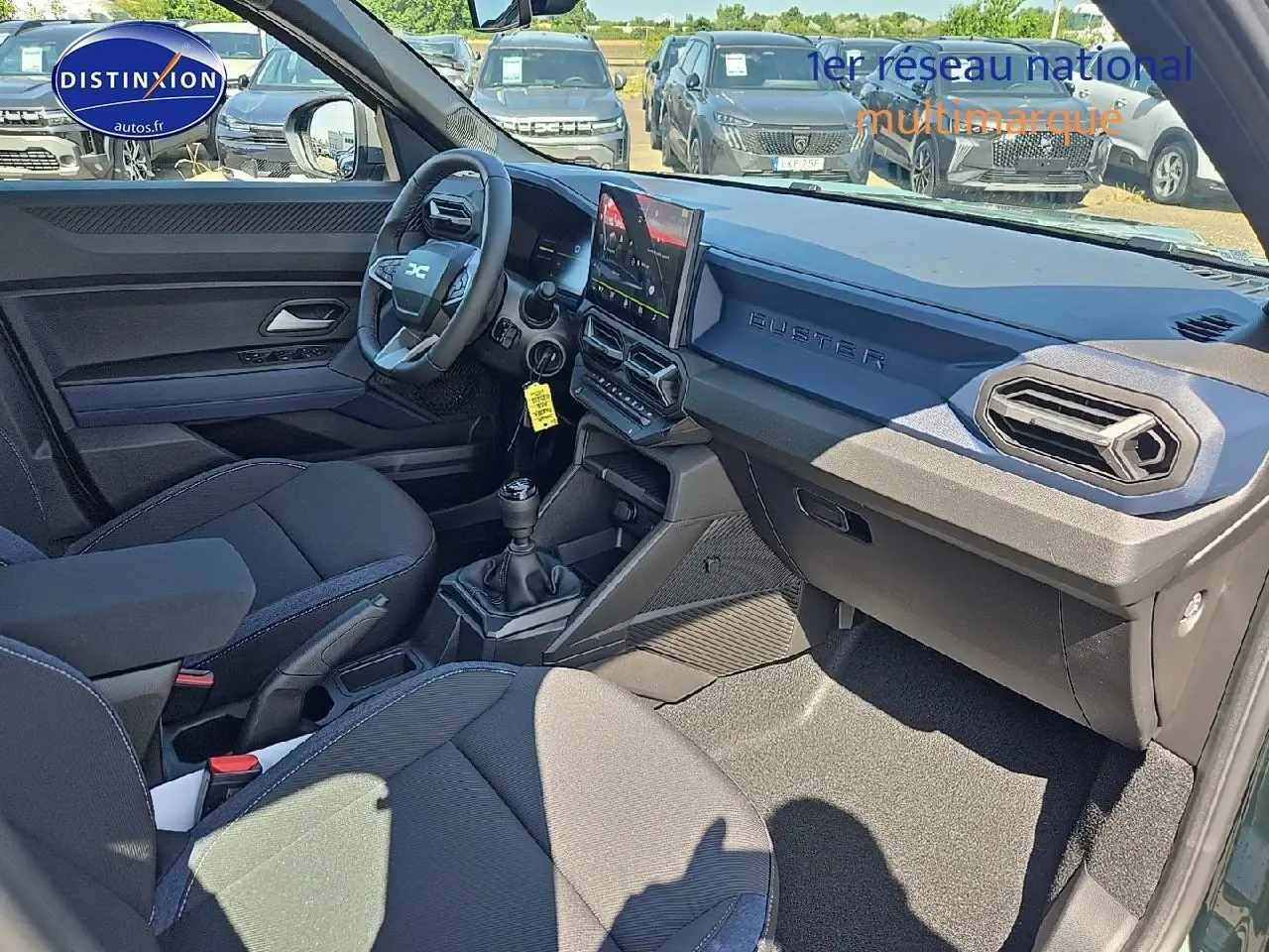 Vue intérieure côté conducteur du Dacia Duster 2025 vert kaki, avec tableau de bord moderne et boîte manuelle.