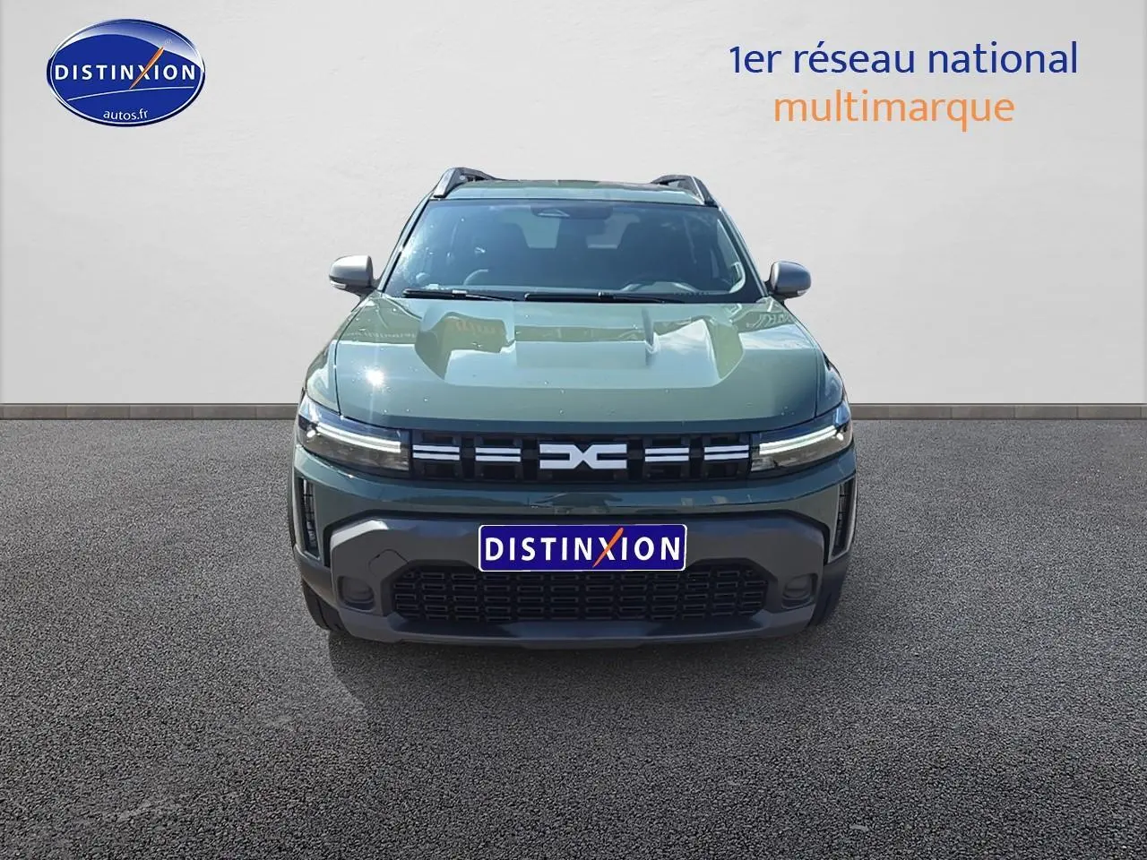 Vue frontale du Dacia Duster 2025 vert kaki avec calandre moderne et phares LED fins allumés.