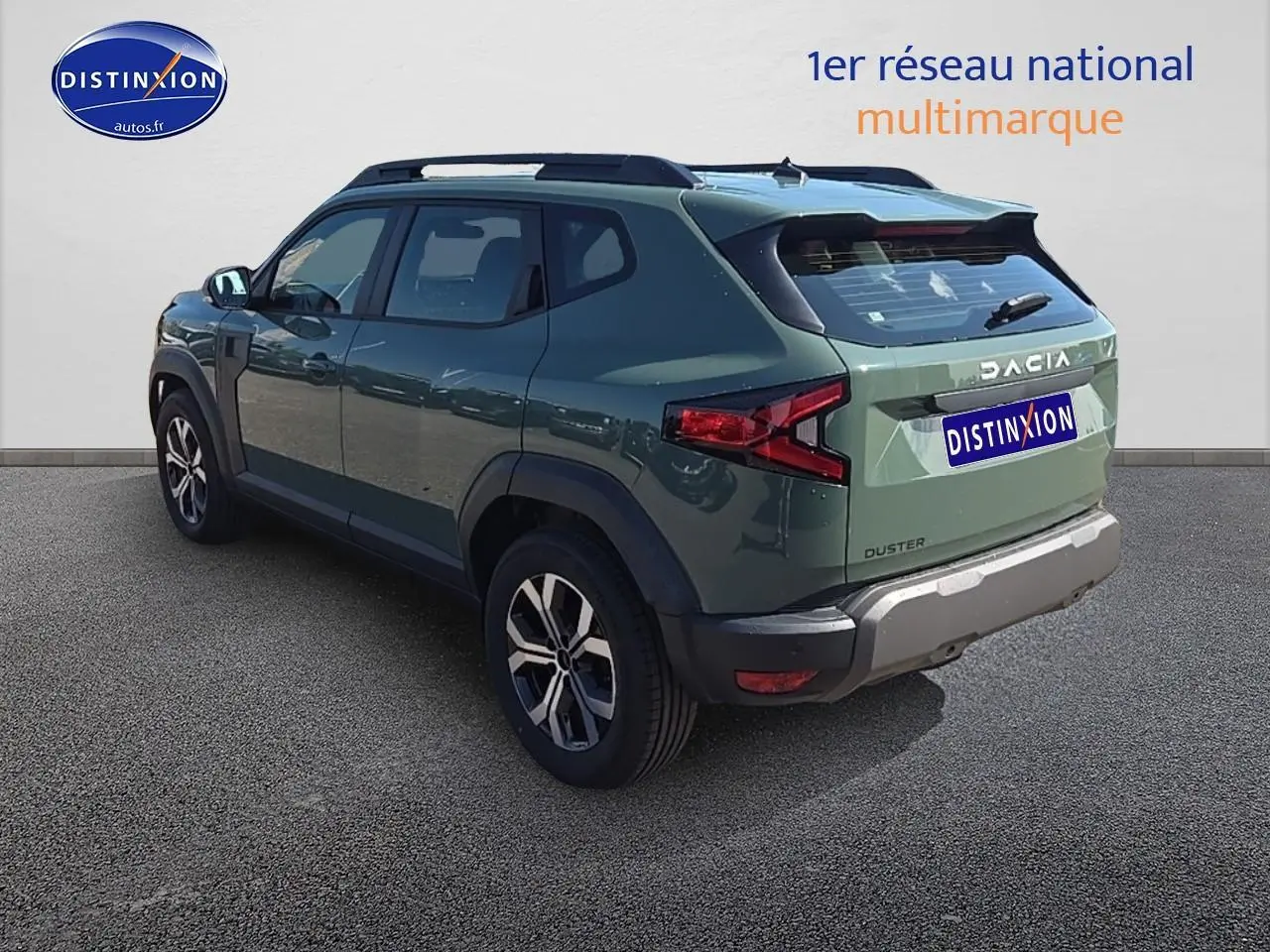 Vue 3/4 arrière droite du Dacia Duster vert kaki 2025 avec jantes alu et barres de toit noires.