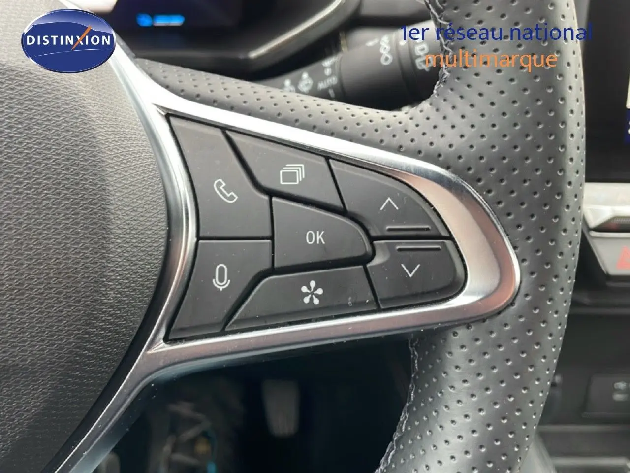 Gros plan sur les commandes multifonctions à droite du volant en cuir perforé noir du Renault Symbioz bleu iron metal.