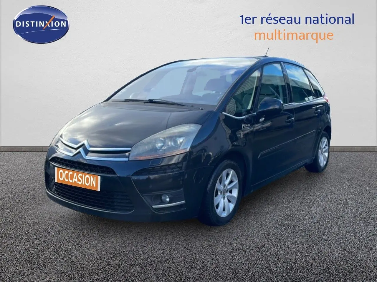 Citroën C4 Picasso noir métal vue 3/4 avant droit avec jantes alliage et calandre chromée.