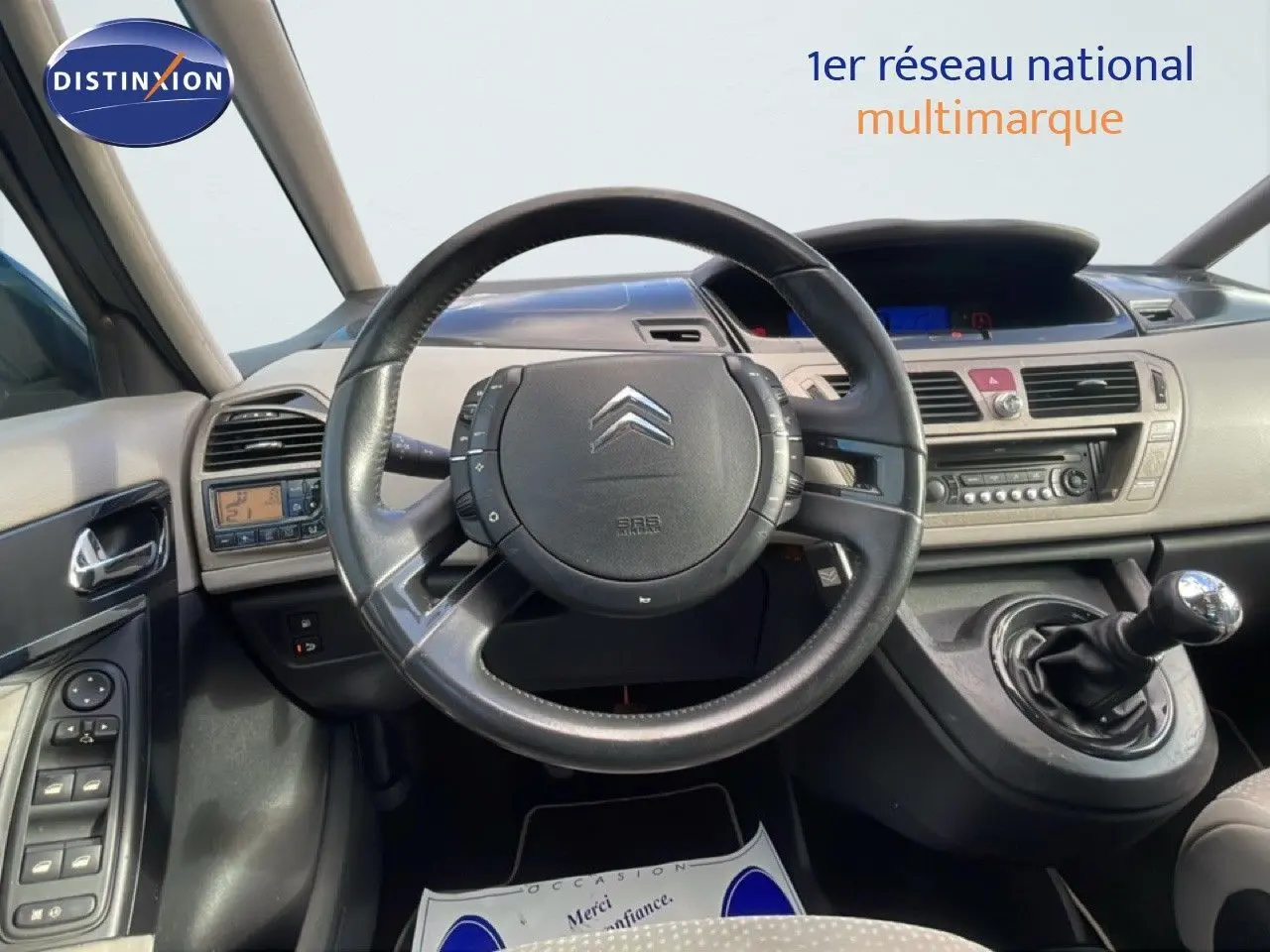 Vue intérieure du poste de conduite de la Citroën C4 Picasso 2008, volant cuir noir et levier de vitesse manuel visible.