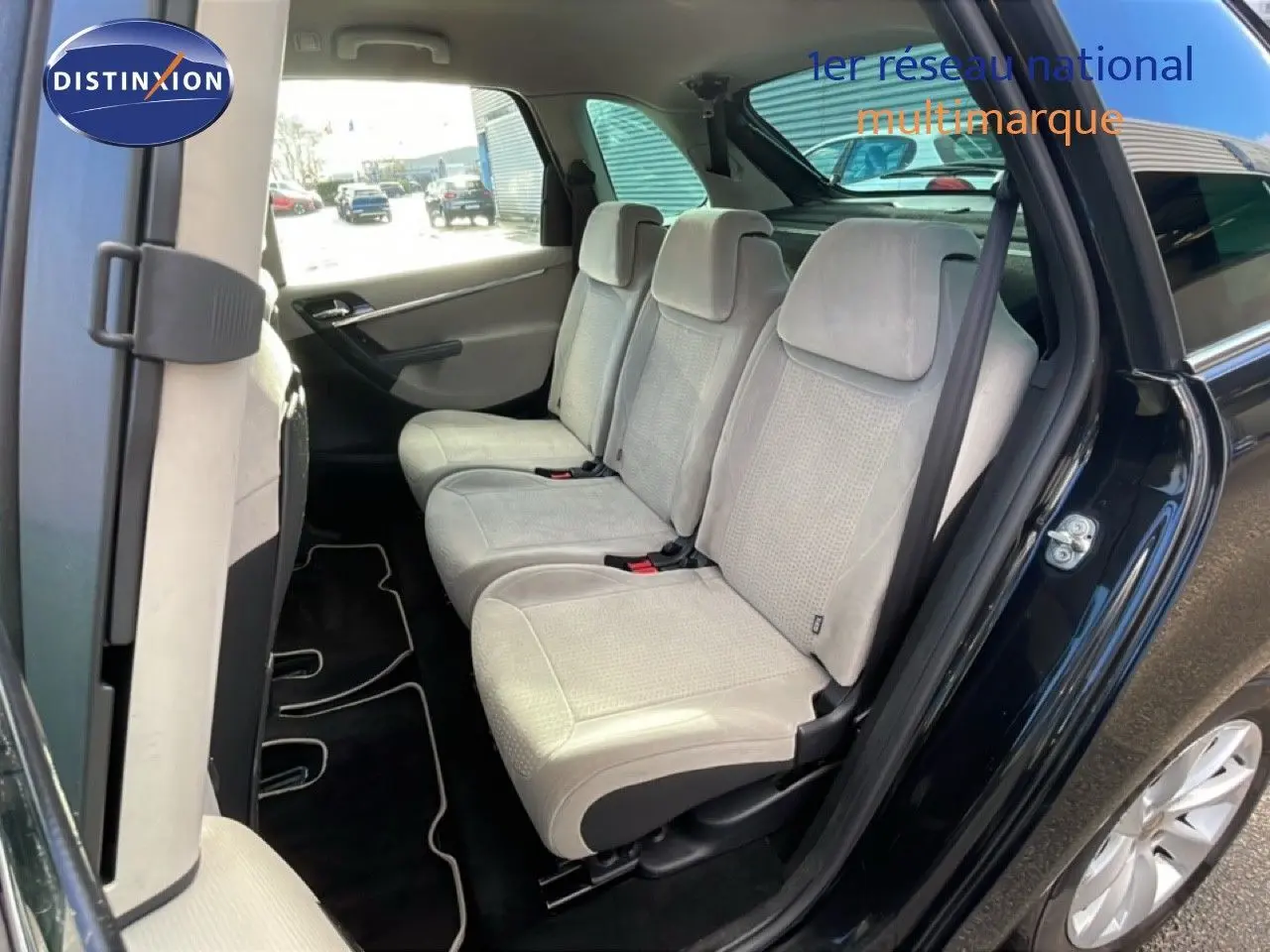 Vue intérieure côté droit montrant les sièges arrière beige clair d'une Citroën C4 Picasso noir métal de 2008.