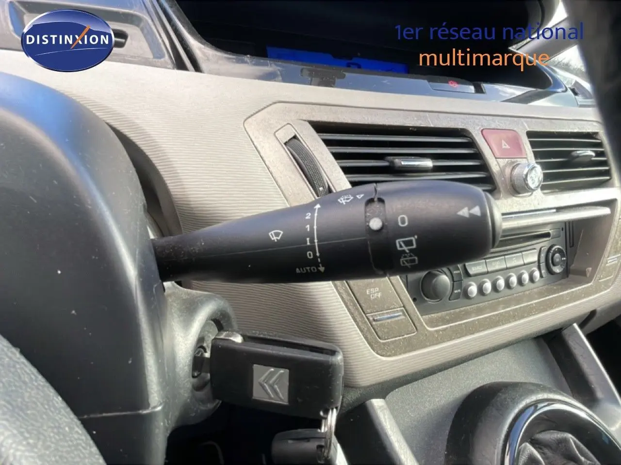 Vue intérieure rapprochée du tableau de bord et commande d’essuie-glace d’une Citroën C4 Picasso noire de 2008.