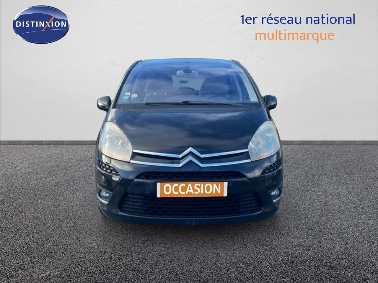 Vue frontale d'une Citroën C4 Picasso noire métal de 2008 avec calandre chromée et phares larges.