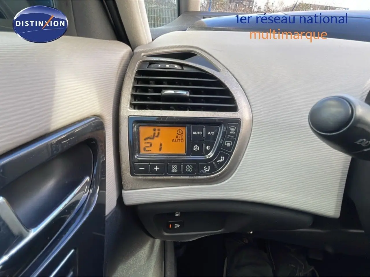 Détail du tableau de bord côté gauche avec commandes de climatisation digitale sur Citroën C4 Picasso noir métal 2008.