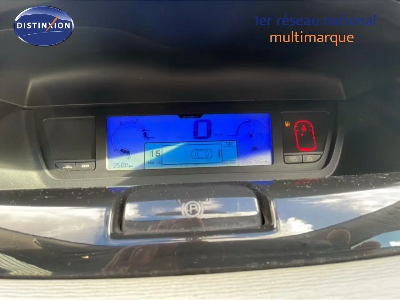Tableau de bord numérique bleu de Citroën C4 Picasso 2008, avec affichage de vitesse et indicateurs, sur fond noir brillant.