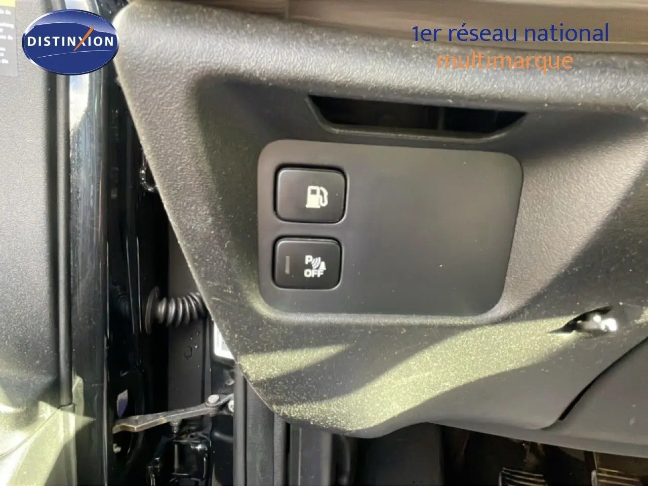 Gros plan sur les boutons d'ouverture de trappe à carburant et désactivation du radar de recul dans un Citroën C4 Picasso noir métal.