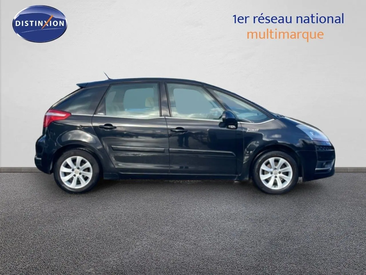 Profil côté gauche d'une Citroën C4 Picasso noire métal de 2008, avec jantes alliage et lignes fluides visibles.