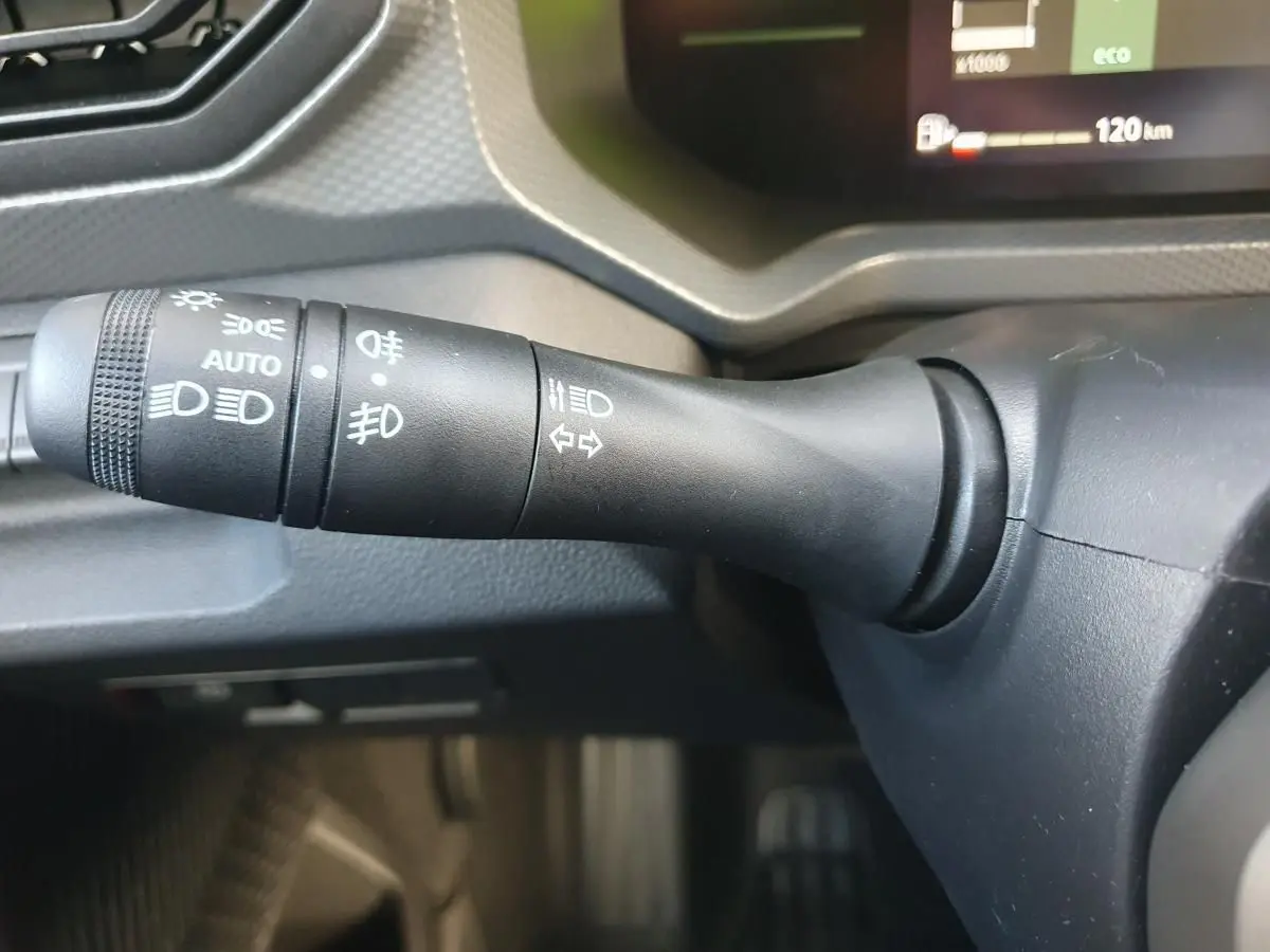 Gros plan sur la commande des feux et clignotants du Dacia Duster 2026, intérieur noir mat.
