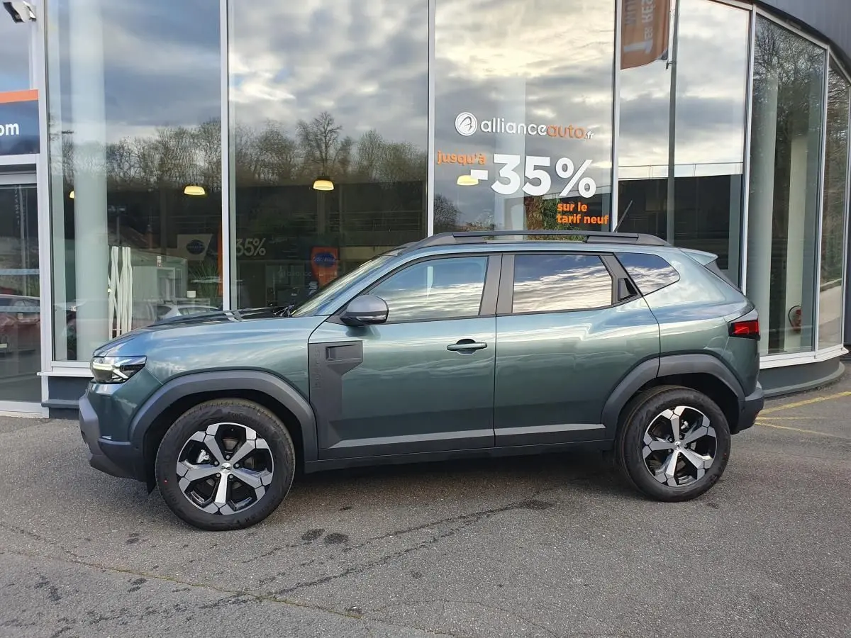 Profil droit du Dacia Duster 2026 vert cèdre avec jantes alliage 18” diamantées et barres de toit longitudinales.