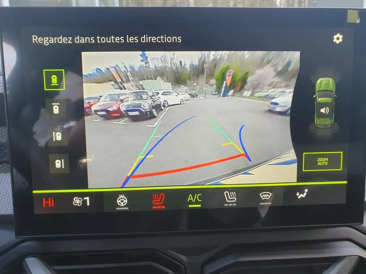 Écran de caméra de recul du Dacia Duster vert cèdre montrant l'arrière et les lignes de guidage colorées.