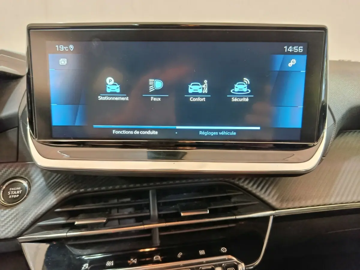 Écran tactile central de 10 pouces du Peugeot 208 PureTech blanc, avec menu des fonctions de conduite affiché.