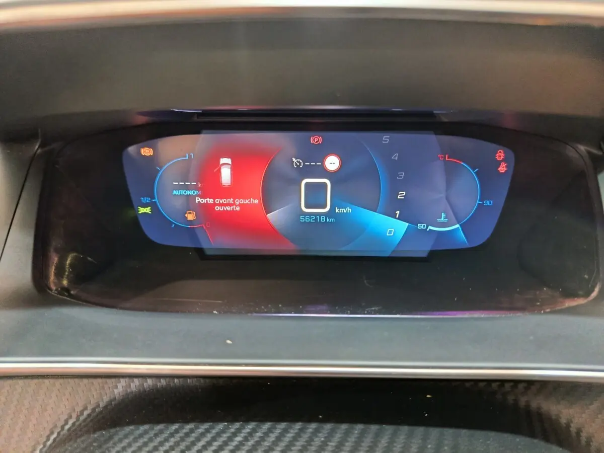 Tableau de bord numérique de Peugeot 208 blanc, affichant porte avant gauche ouverte et compteur digital.
