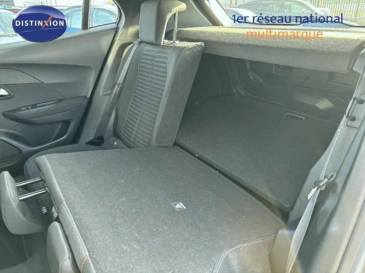 Vue intérieure du coffre et des sièges arrière rabattus côté droit d'un Peugeot 2008 gris Artense 2021.