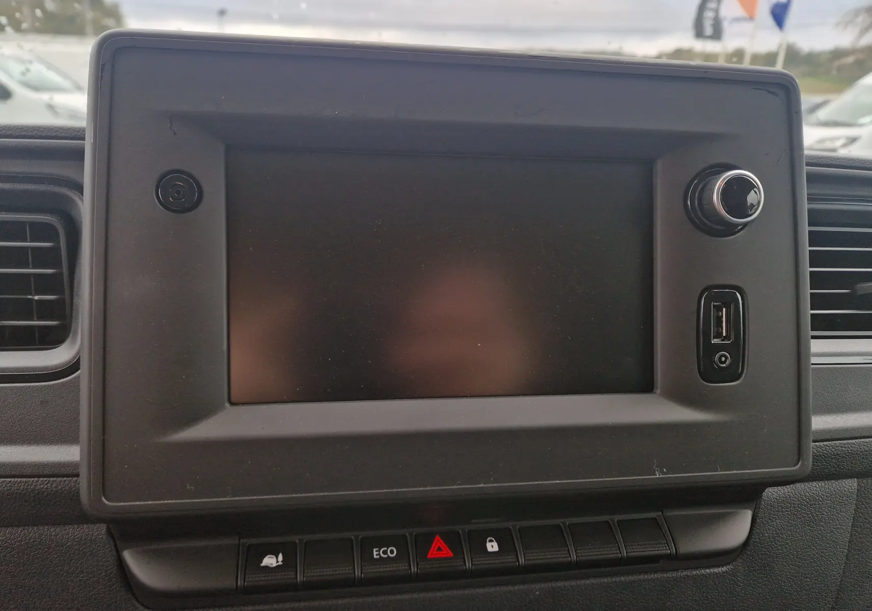 Écran tactile central éteint du tableau de bord du Renault Master blanc, avec commandes Eco et verrouillage visibles en bas.