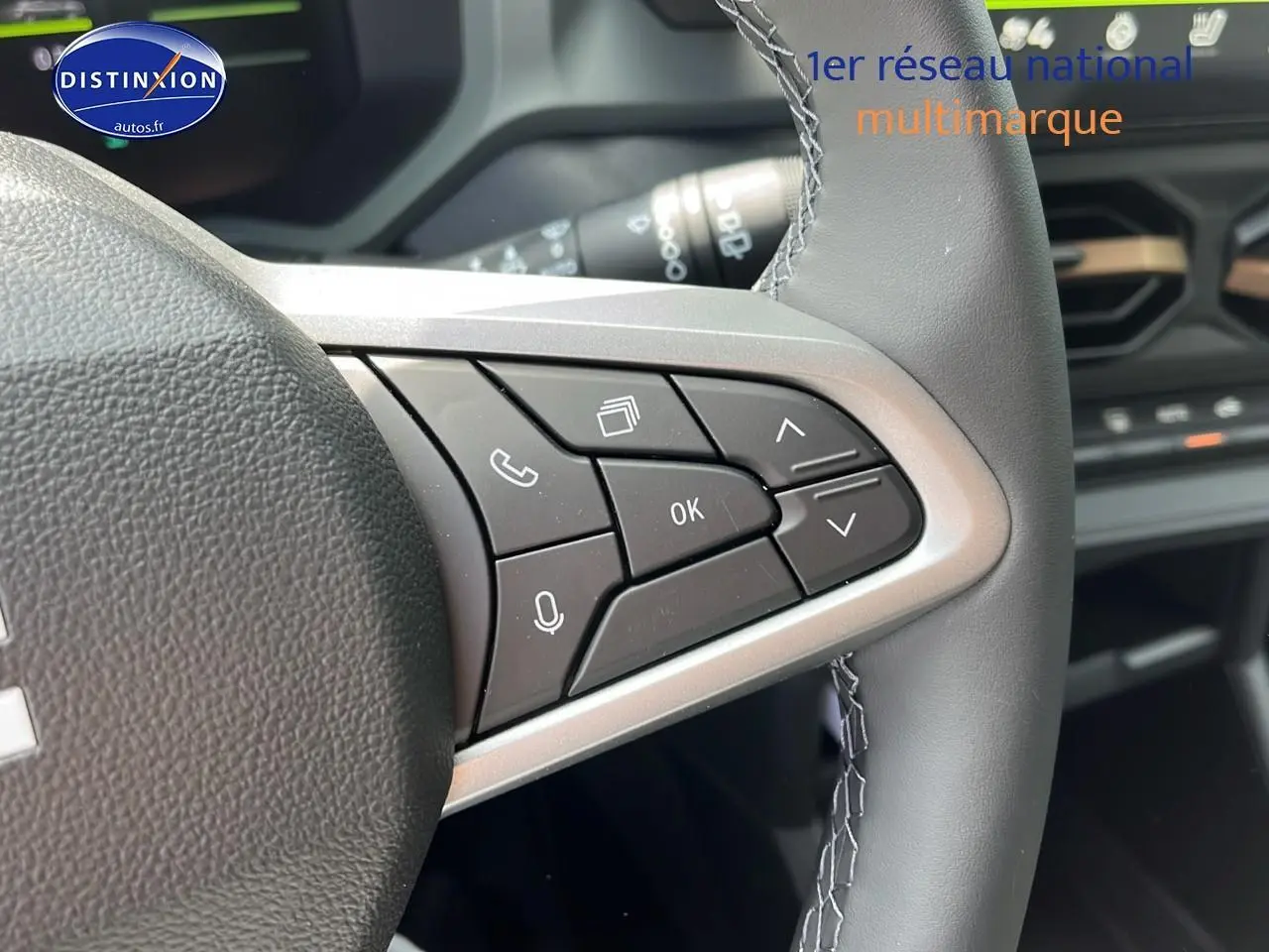 Gros plan sur les commandes au volant côté droit du Dacia Duster noir 2025, avec tableau de bord en arrière-plan.