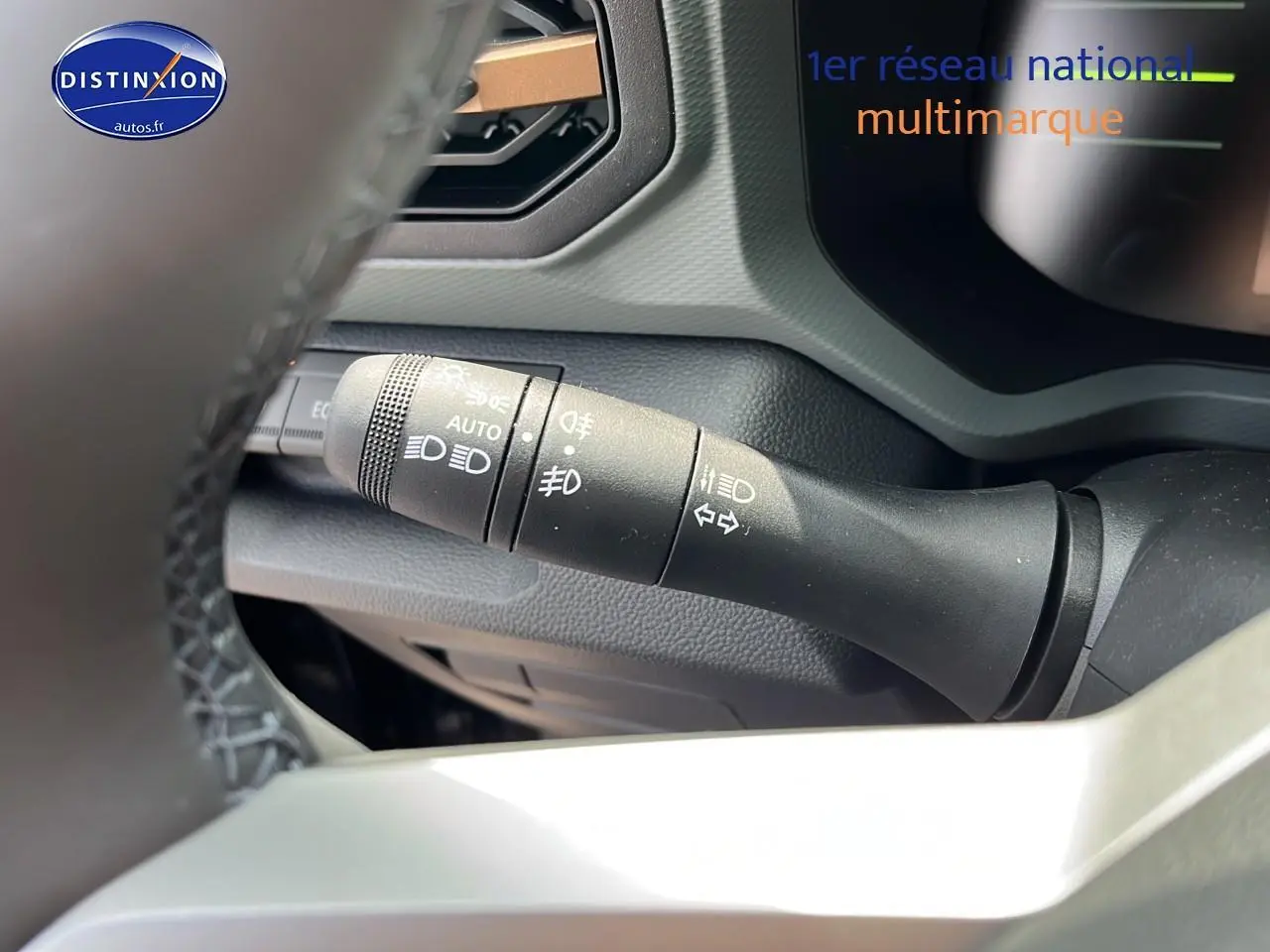 Gros plan sur la commande des phares et clignotants du tableau de bord du Dacia Duster 2025 noir.