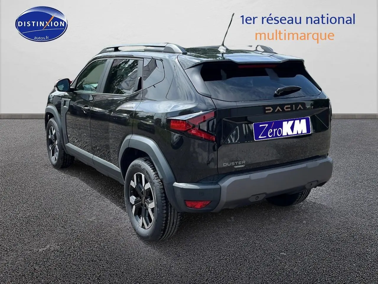 Vue 3/4 arrière droite du Dacia Duster noir 2025 avec barres de toit et jantes alu distinctives.