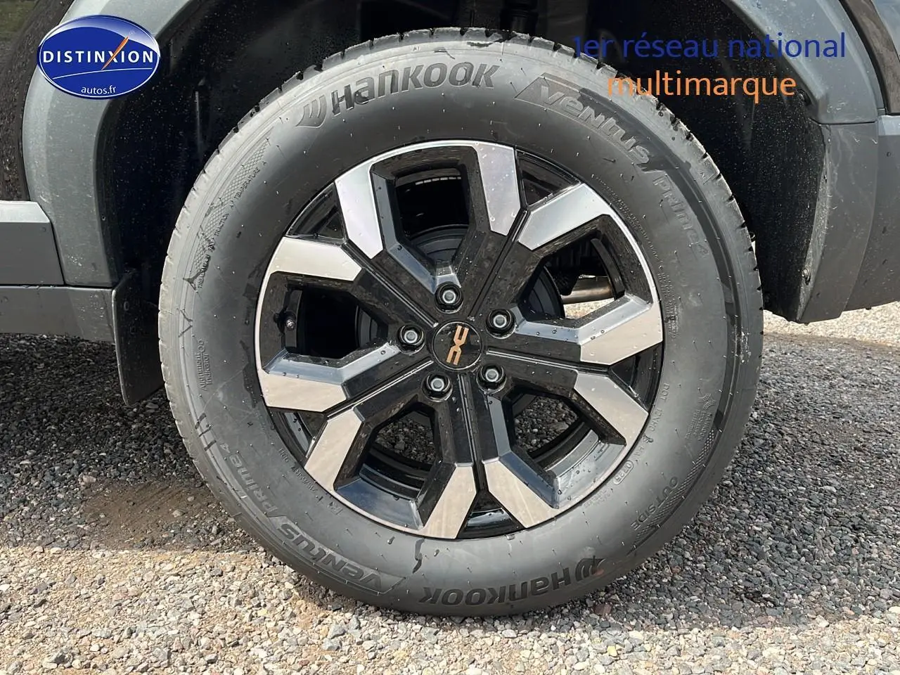 Gros plan sur la roue avant droite du Dacia Duster noir 2025 avec jante alliage et pneu Hankook.