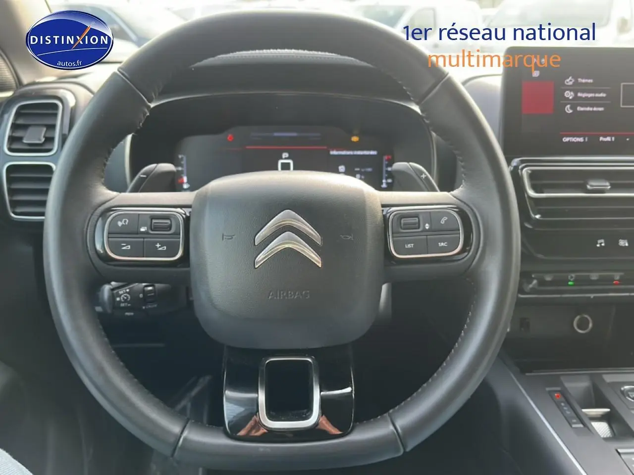 Vue rapprochée du volant cuir multifonction noir du Citroën C5 Aircross 2025 avec tableau de bord numérique et écran tactile.