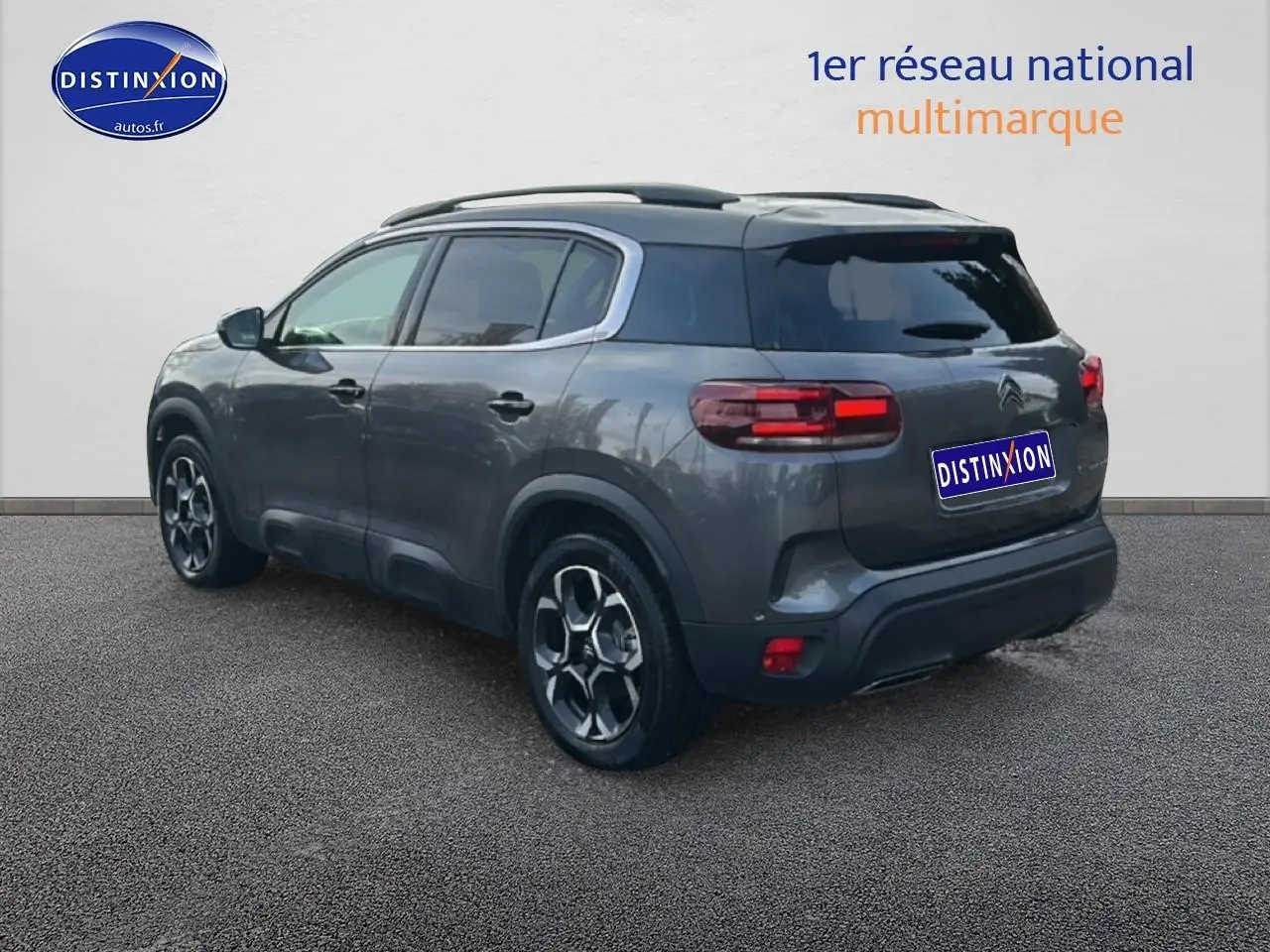 Vue 3/4 arrière droite d'un Citroën C5 Aircross noir avec barres de toit et jantes alliage distinctives.