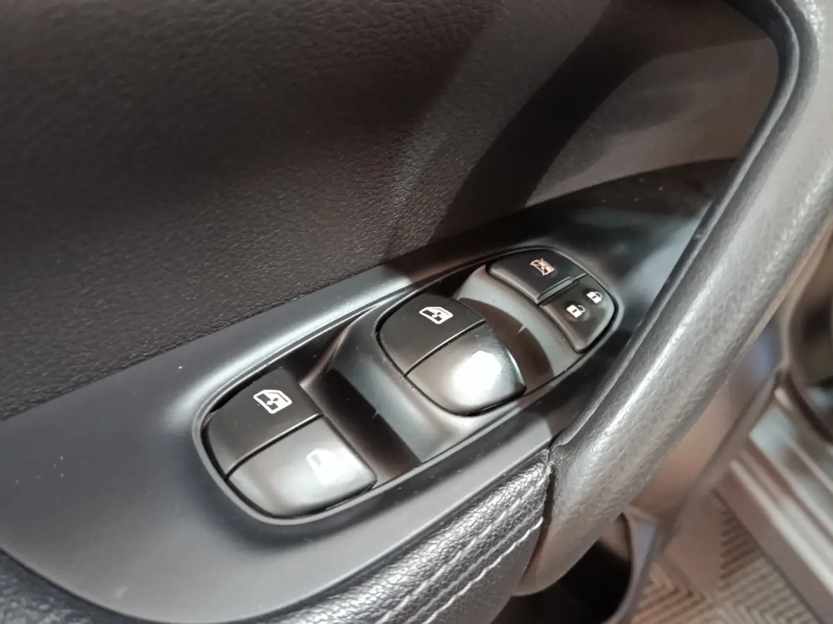 Gros plan sur les commandes de lève-vitres et verrouillage sur la porte côté conducteur du Nissan Qashqai gris clair 2019.