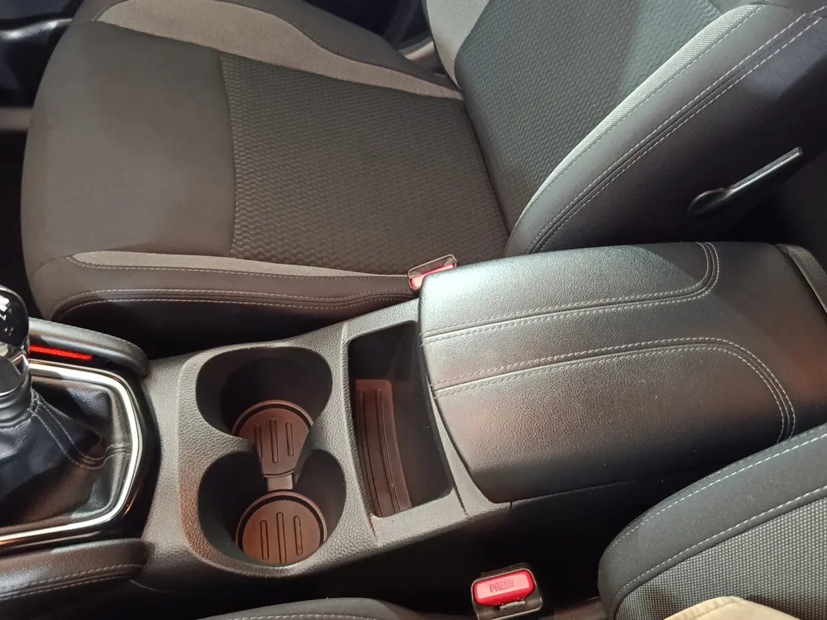 Vue rapprochée de la console centrale noire et des sièges tissu gris foncé du Nissan Qashqai 1.5 DCI 115 Business Edition 2019.