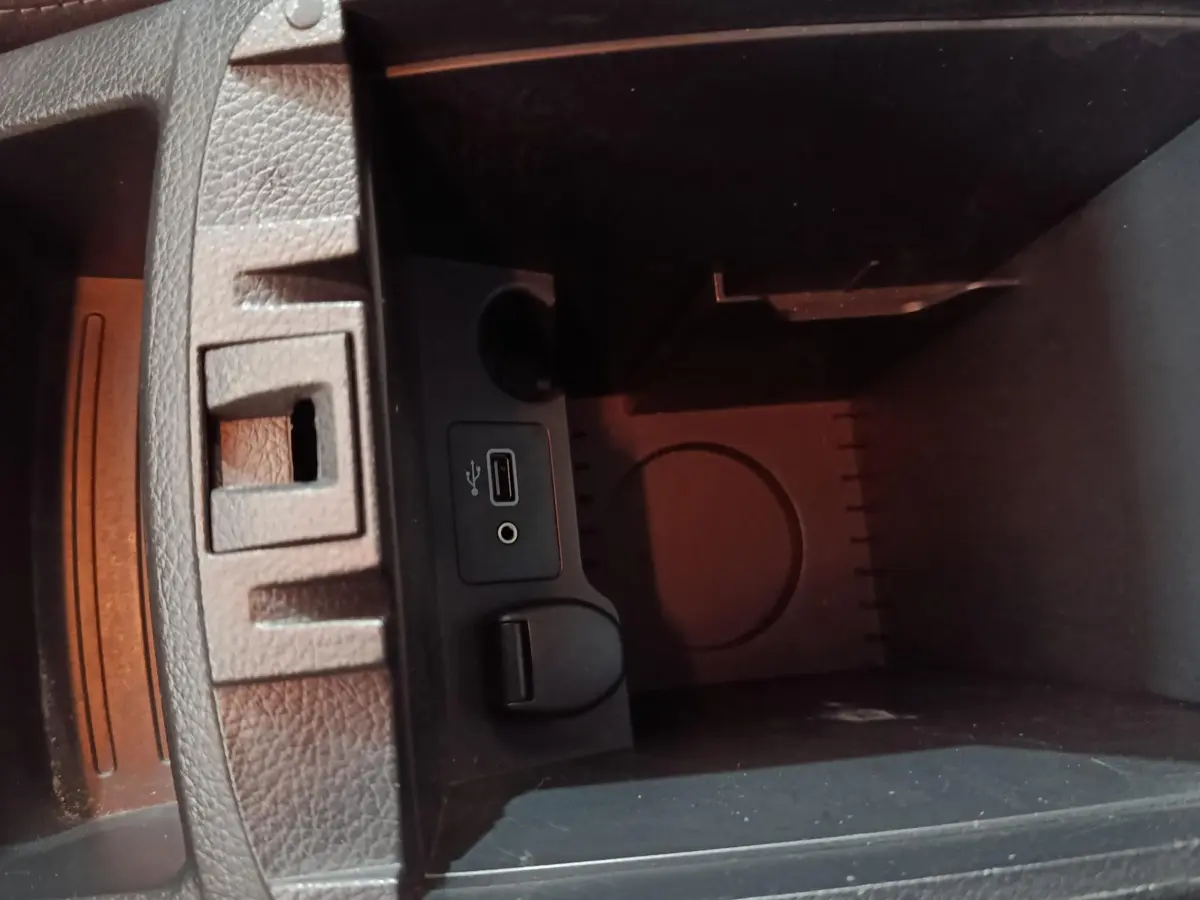 Vue intérieure du compartiment de rangement central du Nissan Qashqai 2019, montrant prises USB et auxiliaire.