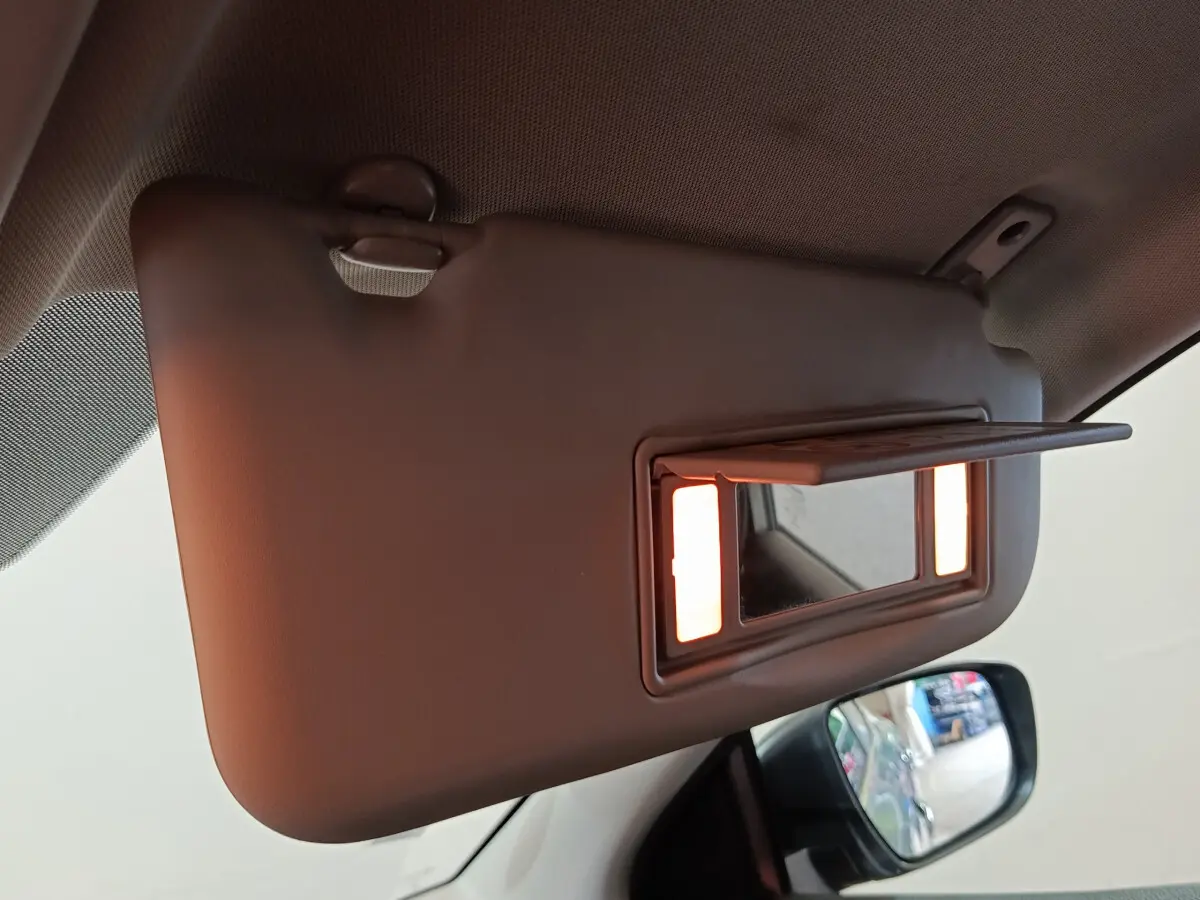 Détail du pare-soleil côté conducteur avec miroir éclairé dans un Nissan Qashqai gris clair 2019.