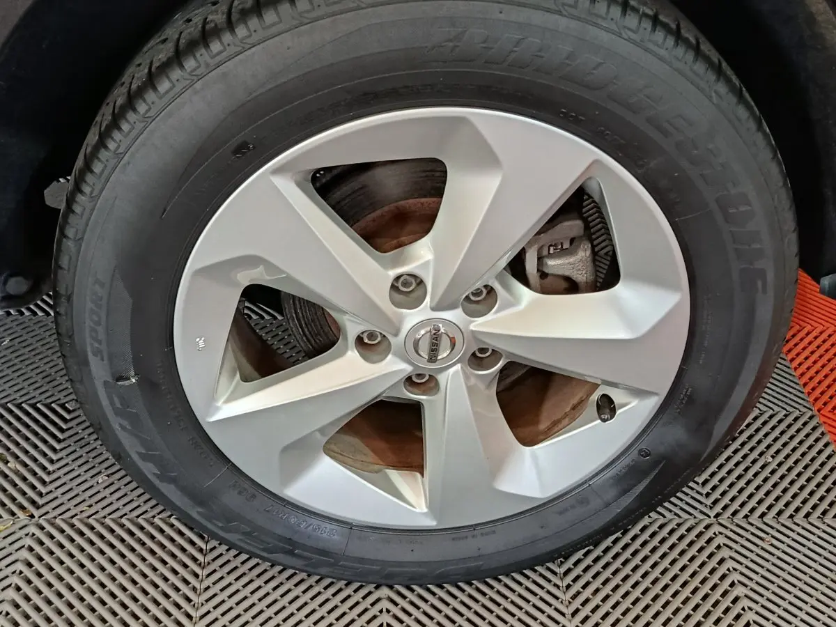 Gros plan sur la roue avant droite avec jante alliage argentée du Nissan Qashqai gris clair 2019.