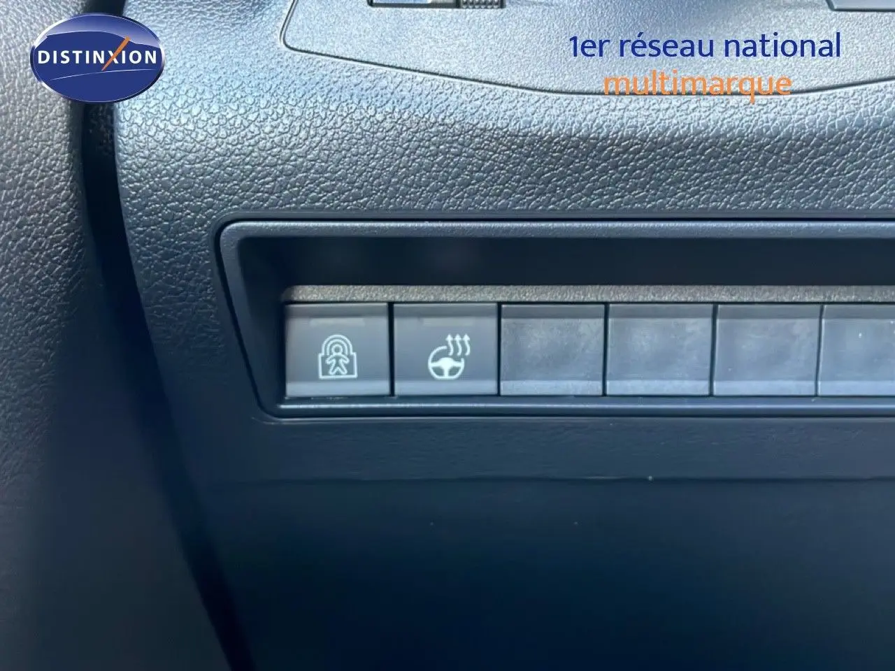 Gros plan sur les boutons de commande du tableau de bord noir du Citroën Berlingo blanc glacier, version 2025.