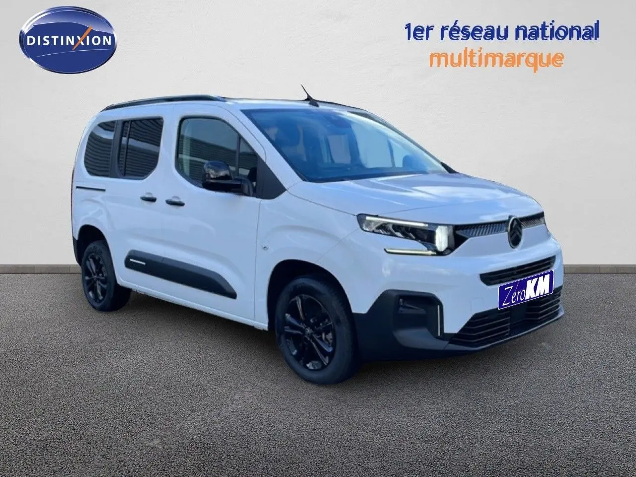 Vue 3/4 avant droite d'un Citroën Berlingo blanc glacier avec jantes noires et protections latérales noires.