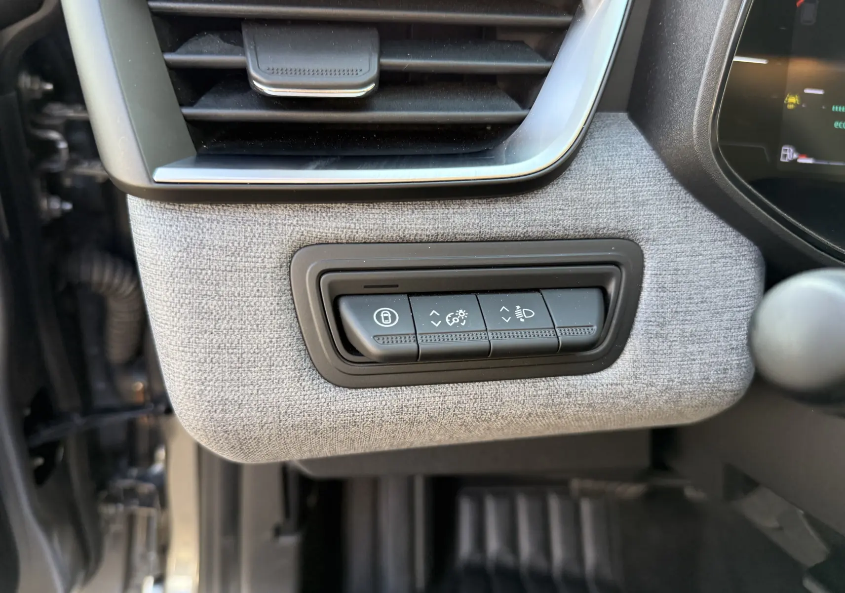 Détail intérieur côté gauche de la planche de bord gris tissu avec commandes de réglage éclairage et verrouillage Renault Clio V 2025.