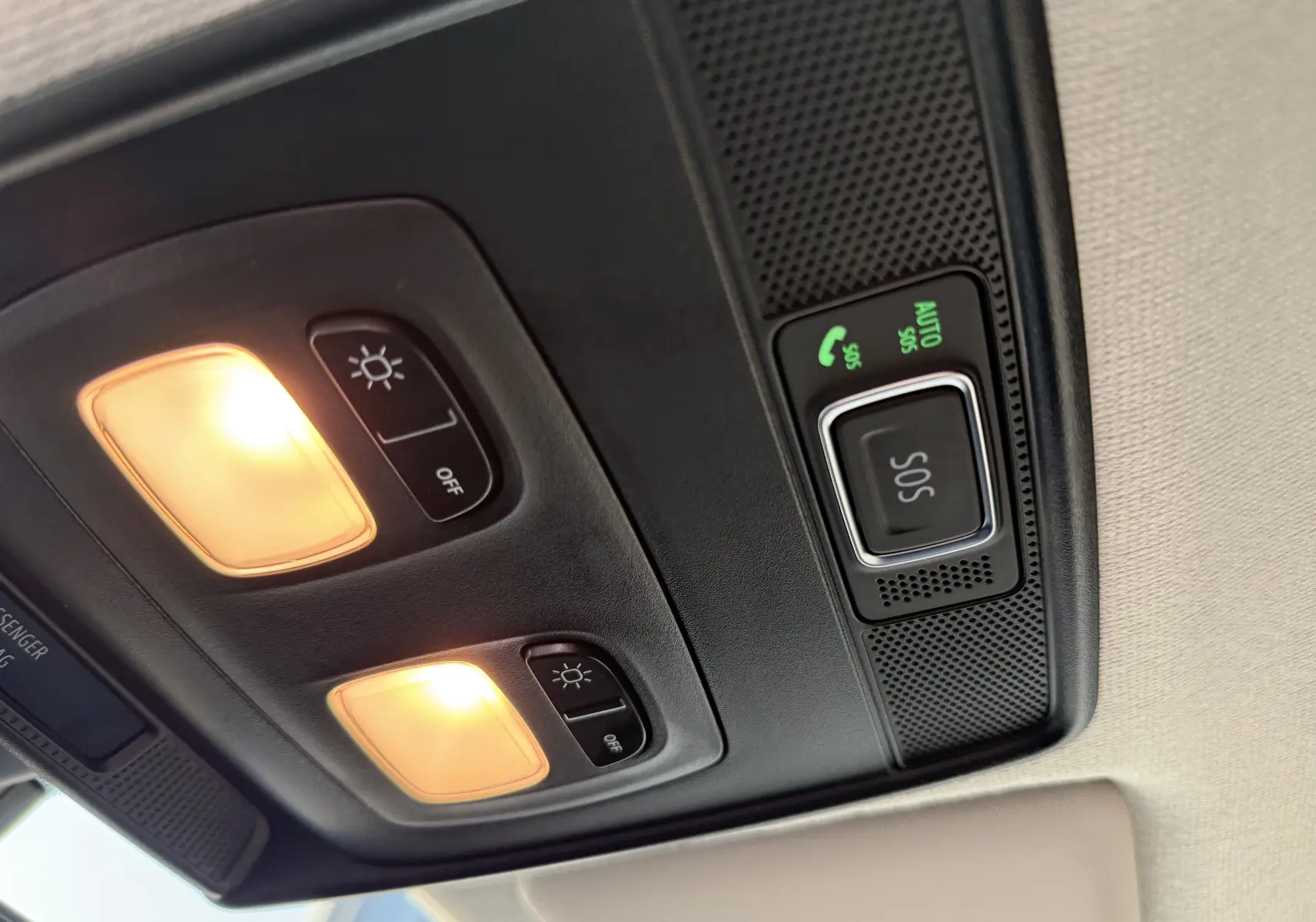Gros plan sur le plafonnier intérieur de la Renault Clio V avec éclairages allumés et bouton SOS lumineux.