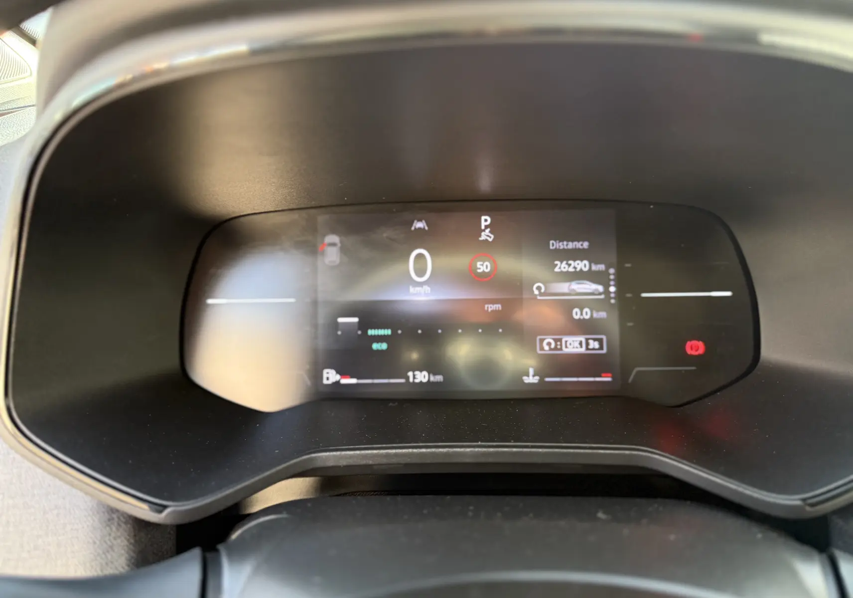 Vue rapprochée du tableau de bord numérique de la Renault Clio V gris schiste, affichant vitesse, distance et alertes.