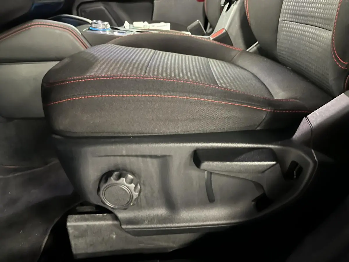 Gros plan sur le siège avant conducteur noir avec surpiqûres rouges du Ford Kuga 2022 version ST-Line.