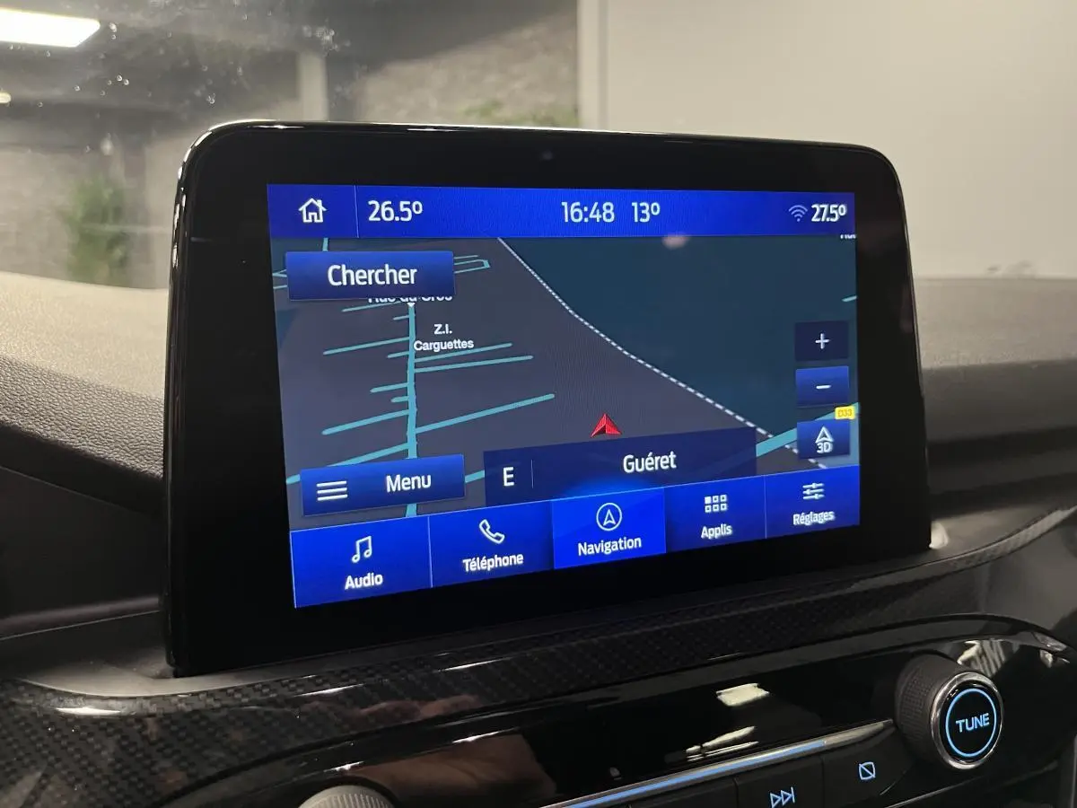 Écran tactile central du Ford Kuga 2022 affichant la navigation avec interface bleue et commandes audio visibles.