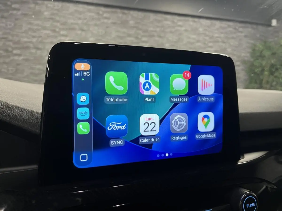 Écran tactile central du Ford Kuga 2022 affichant l'interface Apple CarPlay en intérieur noir.