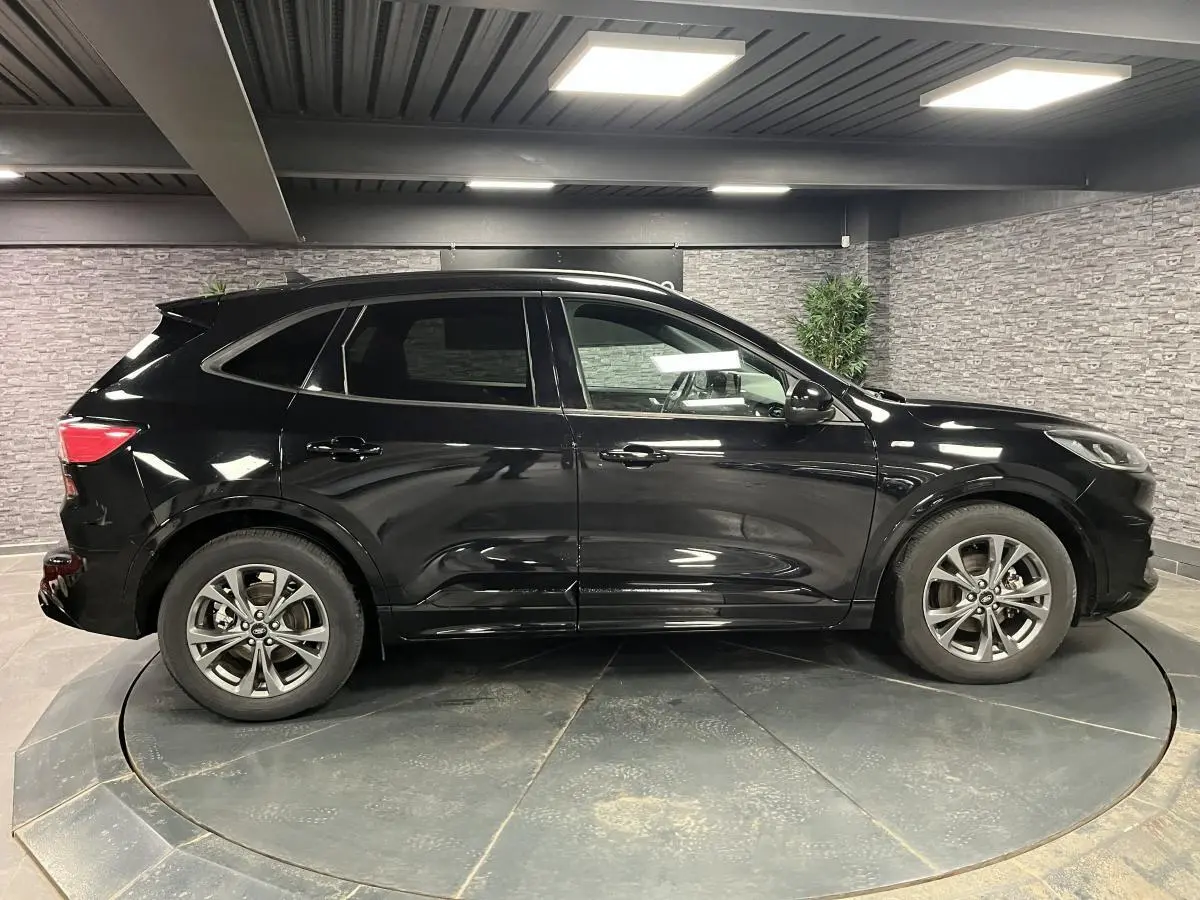 Ford Kuga noir vue de profil côté gauche, avec jantes alliage 18 pouces et vitres arrière surteintées.