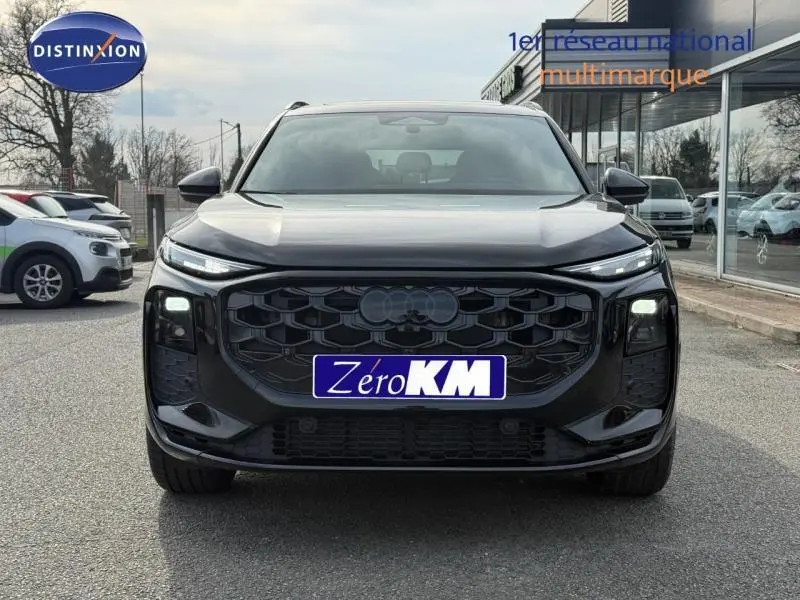 Vue frontale d’un Audi Q3 2.0 TDI 150ch S line noir mythique métallisé, avec calandre noire et phares LED allumés.