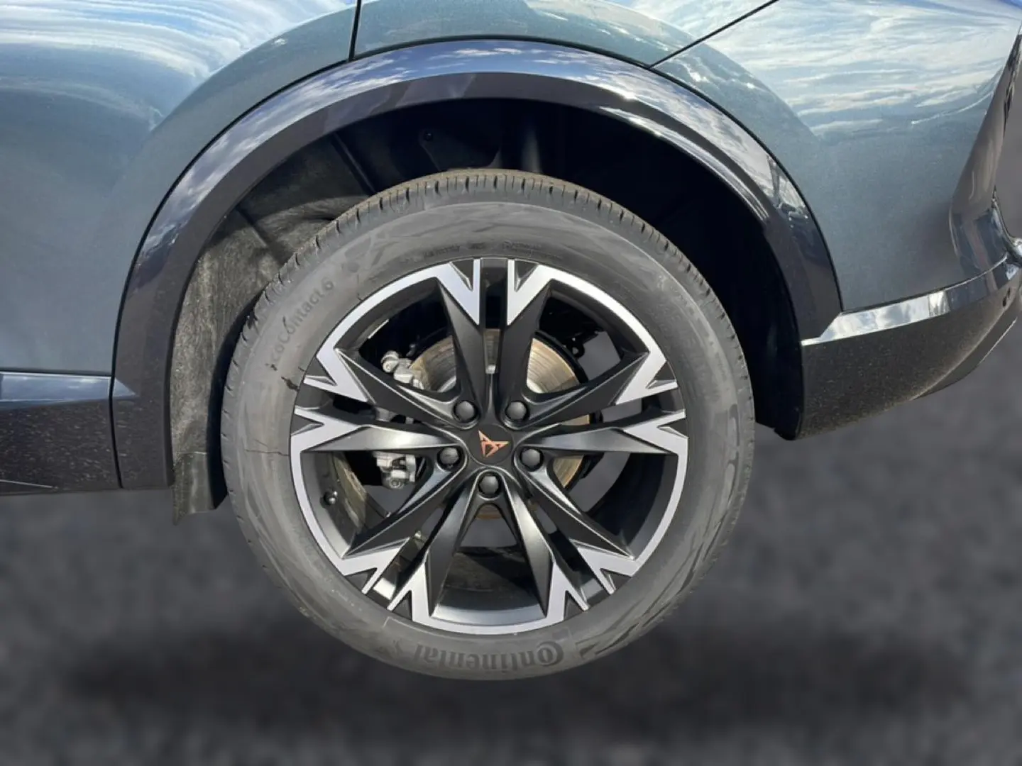 Gros plan sur la roue avant gauche du CUPRA Formentor gris magnétique avec jante noire et argentée au design sportif.