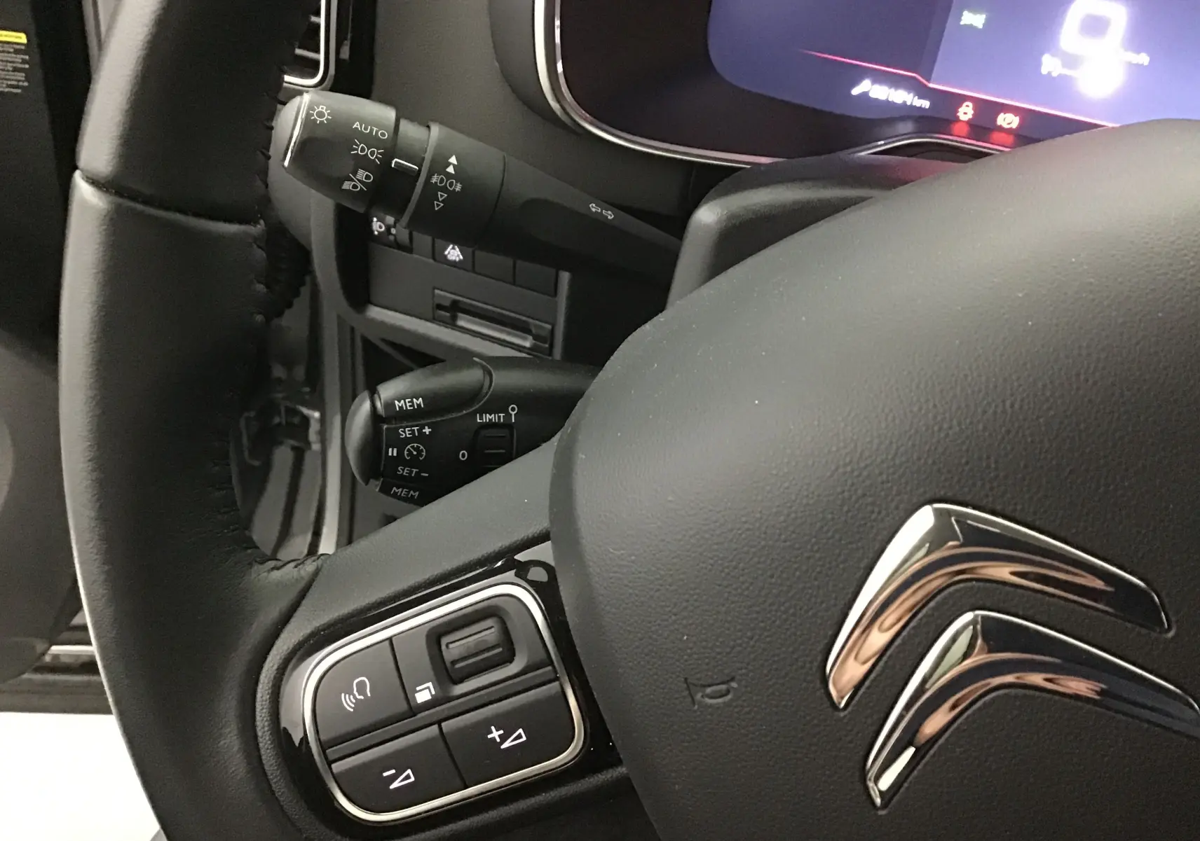 Gros plan sur le volant noir du Citroën C5 Aircross 2021 avec commandes intégrées et tableau de bord numérique partiellement visible.