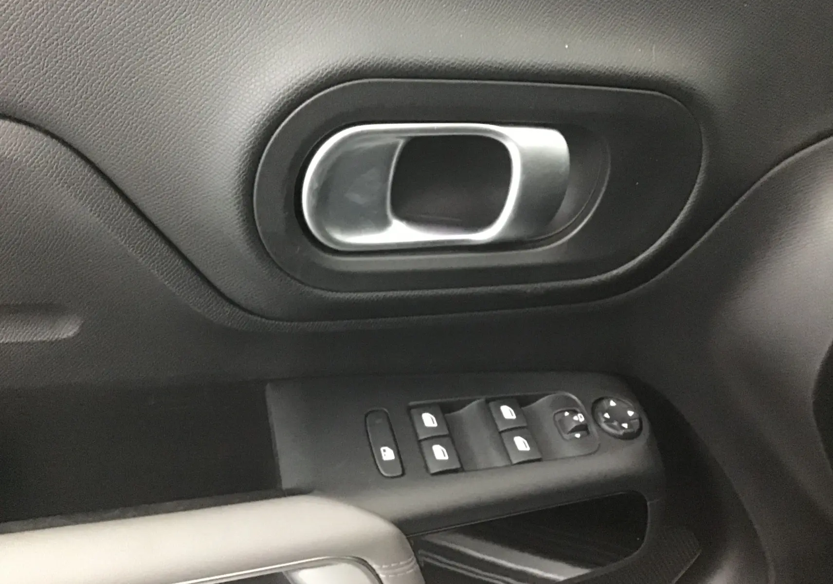 Gros plan sur la poignée de porte intérieure et les commandes des vitres côté conducteur du Citroën C5 Aircross 2021 finition Feel Pack.