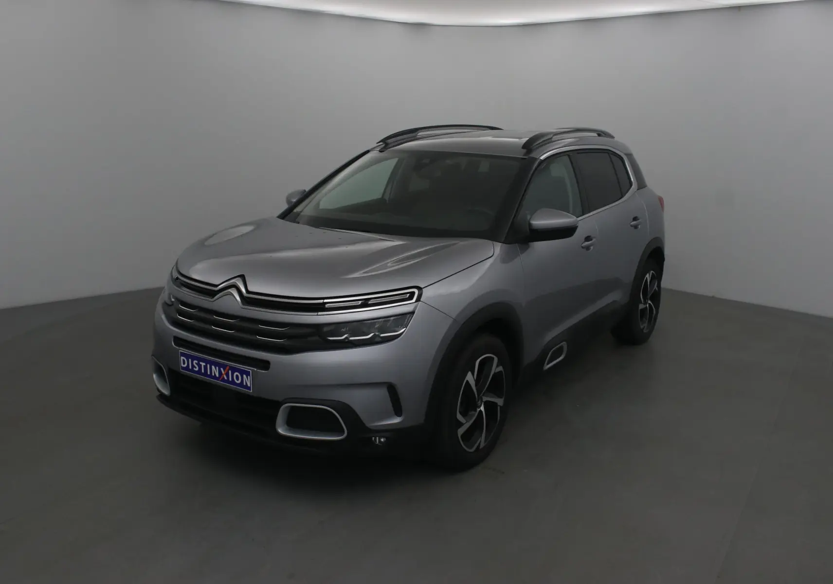 Citroën C5 Aircross gris Artense en 3/4 avant droit, avec jantes noires et toit noir contrastant.