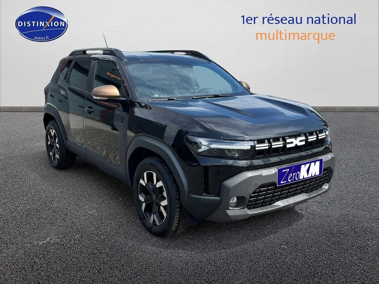 SUV Dacia Duster noir en 3/4 avant droit avec jantes alu et barres de toit visibles.