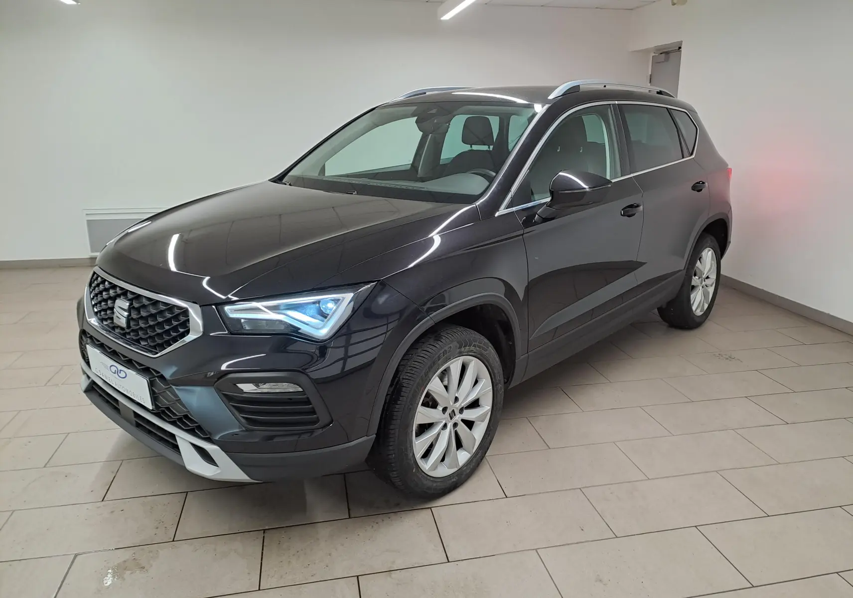 SEAT Ateca 2.0 TDI noir minuit en 3/4 avant droit, avec phares LED allumés et jantes argentées.